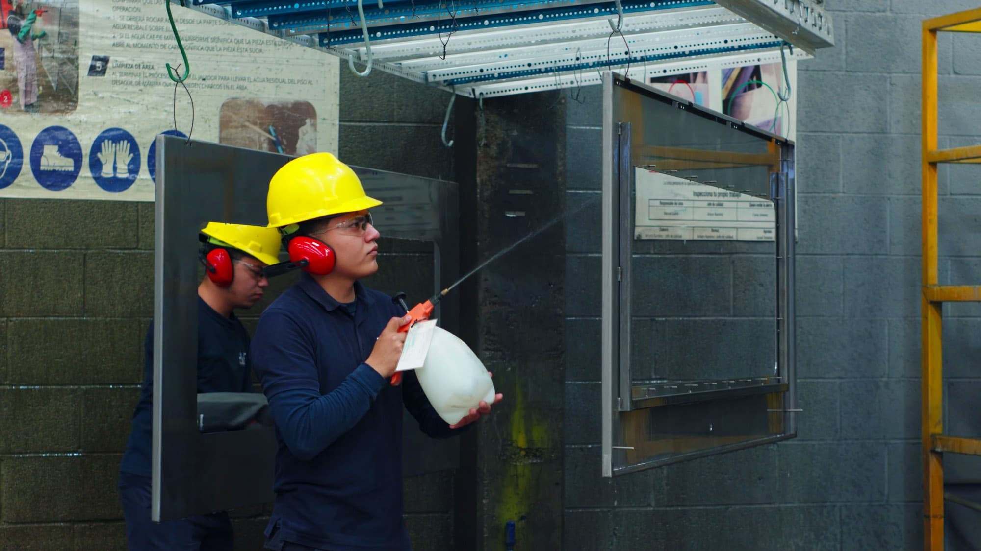 Operadores de Formet CNC preparando la superficie de las piezas antes de pintar